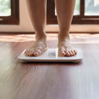 Person steht auf einer Waage, symbolisch für Stoffwechselanalyse und medizinische Labordiagnostik zur Untersuchung von Gewicht, Hormonstatus, Blutzucker und metabolischer Gesundheit.